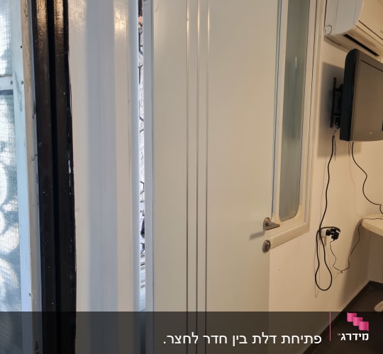 דלת חדשה מותקנת עם צירים בחדר בשיפוץ